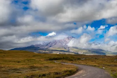 A view of Cotopaxi Volcano hiding behind some clouds in Ecuador.
